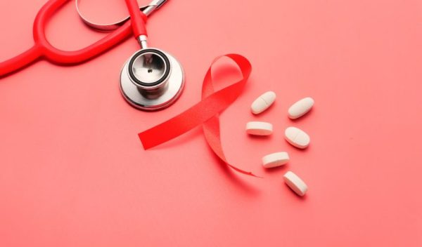 Red Ribbon Hiv, Pills And Stethoscope On Pink Background